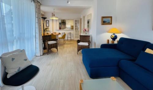 un salon avec un canapé bleu et une table dans l'établissement Le Santorin - Deauville, à Deauville