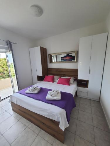 - une chambre avec un grand lit et des serviettes dans l'établissement Apartment D&D, à Bibinje