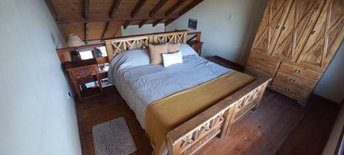 a bedroom with a large bed and wooden floors at Bosque Del Sur Cabañas in Ushuaia