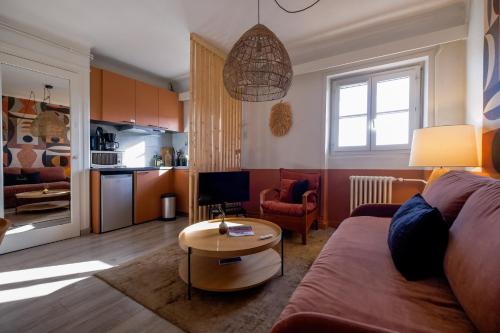 un salon avec un canapé et une table dans l'établissement HONORÊ SUITE CASAMANCE, à Lyon
