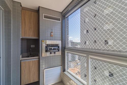 a kitchen with a window with a view at Aptos na PG em excelente localização à 100m da PRAIA no Centro da Cidade com Garagem, Ar Condicionado, Portaria 24H in Praia Grande