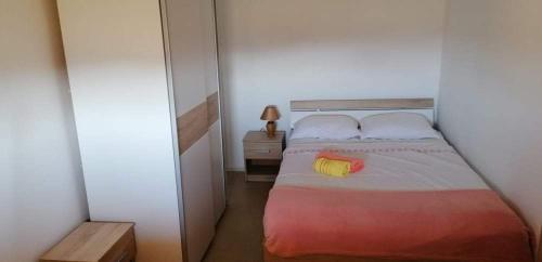 een kleine slaapkamer met een bed met 2 kussens bij Kuća za odmor ANA in Ljubač