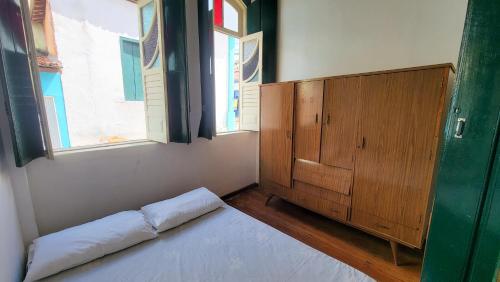 a bedroom with a bed and a wooden cabinet at Casa de Izaura in Lençóis