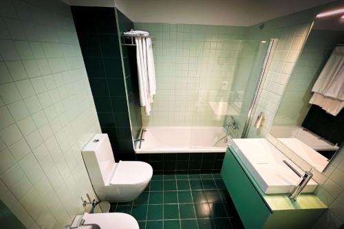 a green bathroom with a toilet and a sink at Casa de Campo Franco da Serra in Angra do Heroísmo