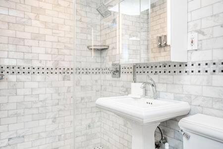 a white bathroom with a sink and a shower at Downtown ATL Condo Walk Score 78 w Free Parking LM1104 in Atlanta