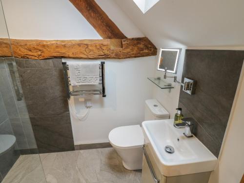 a bathroom with a toilet and a sink at The Stables in Bromsgrove