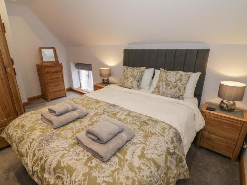 een slaapkamer met een bed met twee handdoeken erop bij The Stables in Bromsgrove