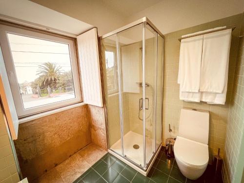 a bathroom with a shower and a toilet and a window at Casa de Campo Franco da Serra in Angra do Heroísmo