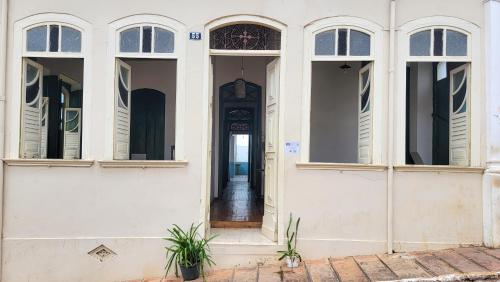a white building with a wooden door and windows at Casa de Izaura in Lençóis