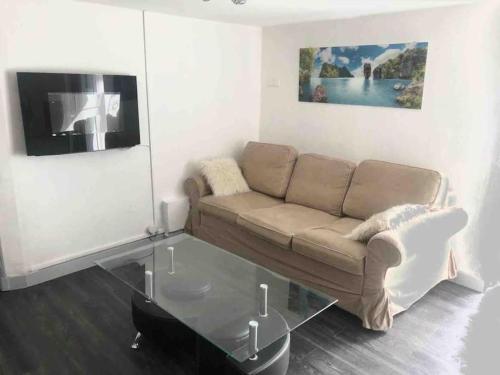 - un salon avec un canapé et une table en verre dans l'établissement Logement appartement bourget, au Bourget