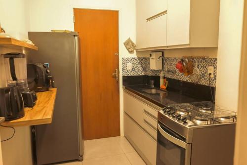 a kitchen with a stainless steel refrigerator and a sink at Ótimo ap - Humaitá/Botafogo in Rio de Janeiro