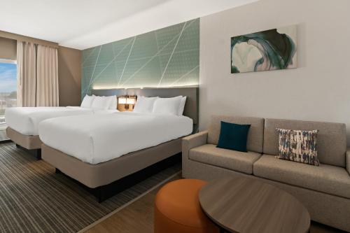 une chambre d'hôtel avec un grand lit et un canapé dans l'établissement Comfort Suites, à Granbury