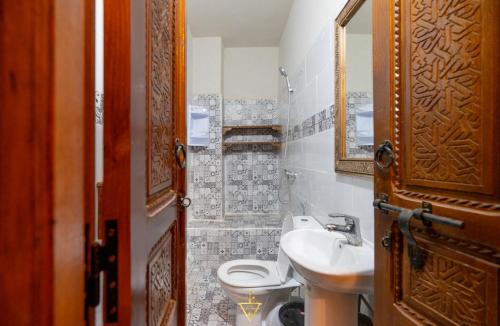 a bathroom with a toilet and a sink and a mirror at Riad Village in Imlil