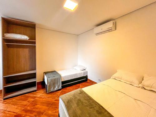 a small room with two beds and a closet at Flat a beira mar da Praia de Guaratuba Bertioga SP in Praia Guaratuba
