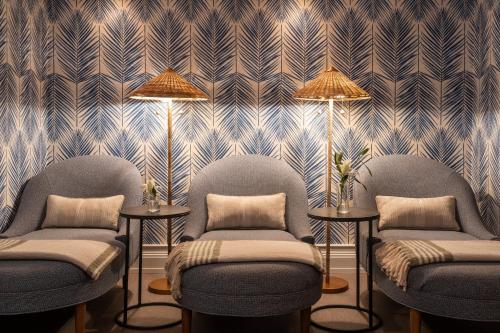a room with three chairs and a wall with a wallpaper at Omni Hilton Head Oceanfront Resort in Hilton Head Island