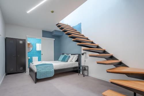 a bedroom with a bed and a spiral staircase at Social Lodge - Piornais in Funchal