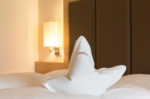 a white pillow shaped like a swan sitting on a bed at Astor Hotel in Schenna