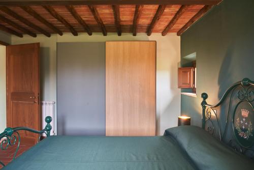a bedroom with a bed and a wooden door at Podere Sant'Antonio in Asciano