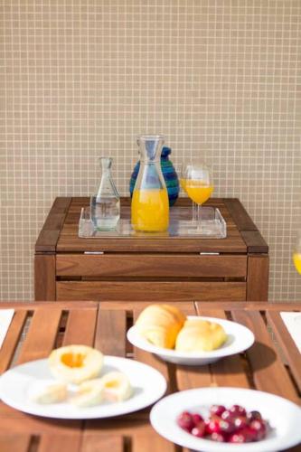 a table with plates of fruit and glasses of orange juice at Sea View - Charming apartment in Vila do Conde