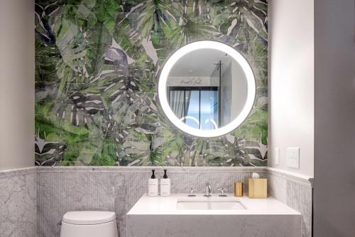 a bathroom with a sink and a mirror at The Ray Hotel Delray Beach, Curio Collection By Hilton in Delray Beach