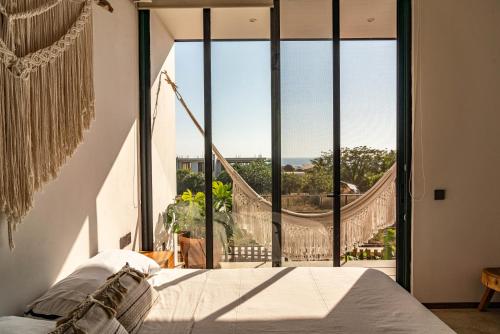 a bedroom with a bed and a large window at La Barra Resorts Puerto Escondido in Puerto Escondido
