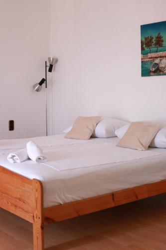 a bed with white sheets and pillows on it at Apartments Mrdan in Seget Vranjica