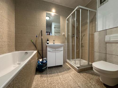 W łazience znajduje się toaleta z umywalką i prysznic. w obiekcie Pokoje Centrum/ rooms in Centre w Warszawie