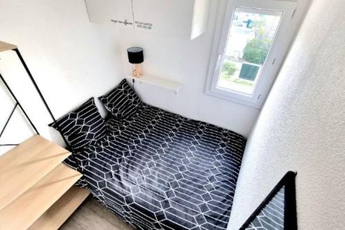 Cette petite chambre offre une vue de tête sur un lit. dans l'établissement Appartement Iris Résidence les Grenadines, à Gruissan