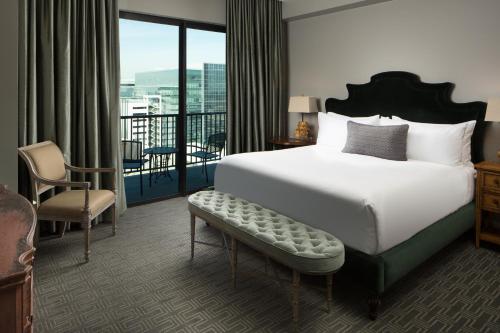 a hotel room with a bed and a balcony at Hotel ZaZa Houston Memorial City in Houston
