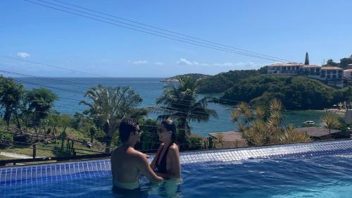 a man and a woman standing in a swimming pool at HOTEL VILLE LA PLAGE & BEACH CLUB in Búzios