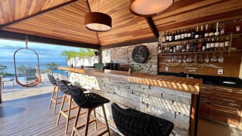 a bar with chairs and a stone wall at HOTEL VILLE LA PLAGE & BEACH CLUB in Búzios
