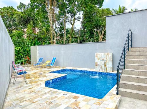 a swimming pool with blue chairs and stairs at Incrivel flat a beira mar na Praia de Guaratuba SP in Praia Guaratuba