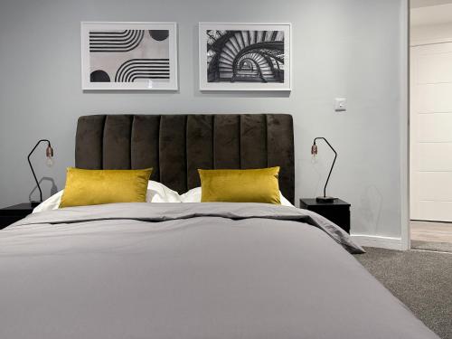 a bedroom with a large bed with yellow pillows at Toothbrush Apartments - Town Centre - Century House in Ipswich