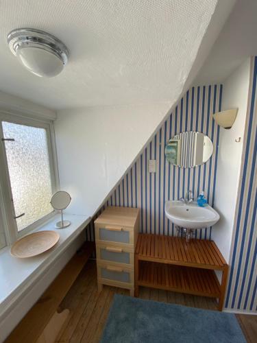 a bathroom with a sink and a mirror and a window at Sofort am Strand! in Kiel
