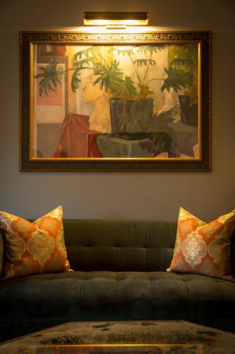 a couch in a living room with a painting on the wall at Hotel ZaZa Houston Memorial City in Houston