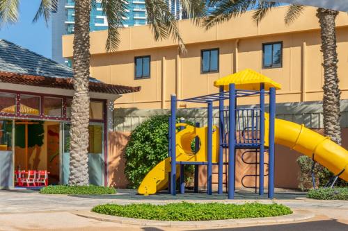 a playground with a slide in front of a building at Sheraton Abu Dhabi Hotel & Resort in Abu Dhabi