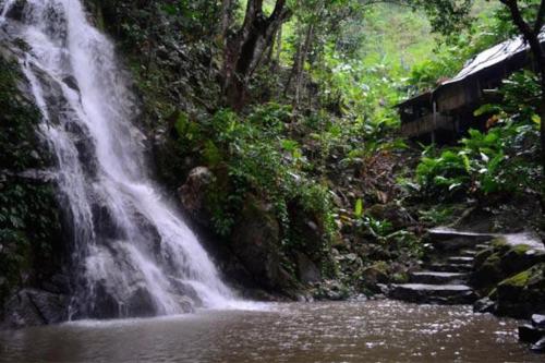 a waterfall in the middle of a river at Cabaña con piscina en Minca in Minca