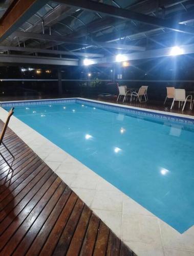 a large blue swimming pool with chairs and tables at Get a Flat 401 - Duplex Luxuoso in São Paulo