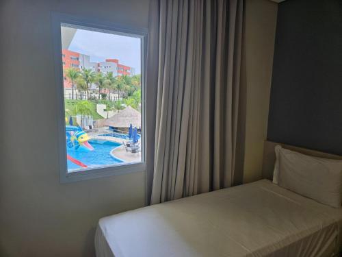 a bedroom with a window with a view of a pool at Vinhedo Plaza Hotel in Vinhedo