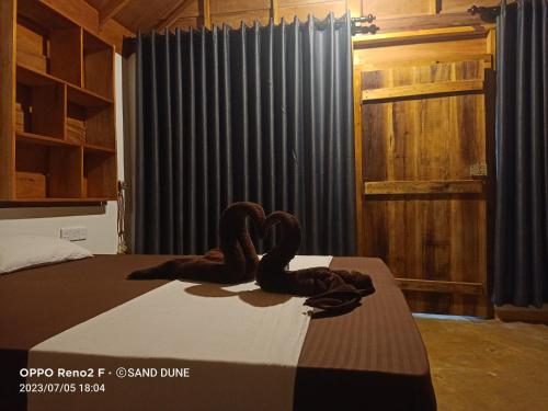 two swans sitting on a bed in a bedroom at Sand Dune Beach Resort & Surf Camp in Arugam Bay