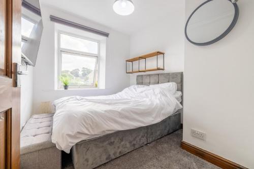 a bedroom with a large bed and a window at Countryside Getaway in Clayton West