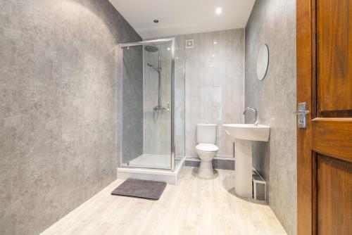 a bathroom with a shower and a toilet and a sink at Countryside Getaway in Clayton West