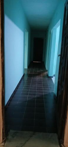 an empty hallway with blue walls and tile floors at Mburucuya in Mburucuyá