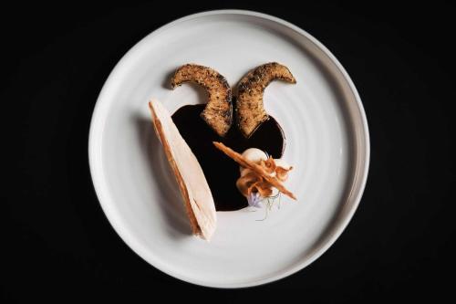 a plate of food with a piece of cake on it at Alpine Resort Sportalm in Sankt Leonhard im Pitztal