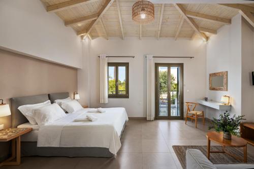 Callisto Seaside Homes & Suites في ماراثوبوليس: غرفة نوم بسرير كبير وغرفة معيشة