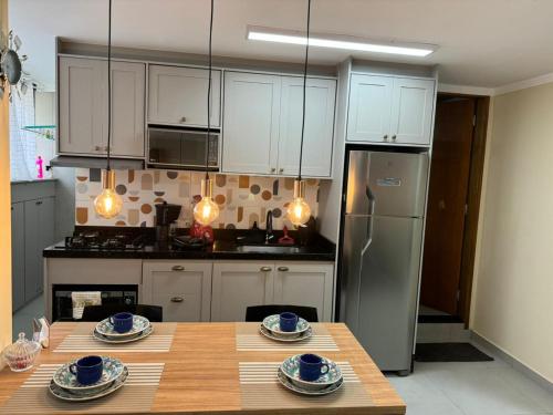 a kitchen with a wooden table and a refrigerator at Apto aconchegante cecapGuarulhos in Guarulhos