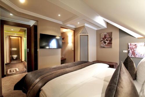 a bedroom with a large bed and a flat screen tv at Grütter Luxury Apartments in Ischgl