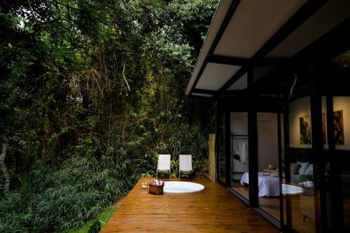 a wooden deck with two white tubs in a forest at CHALÉ NAMATA 201 in São Roque
