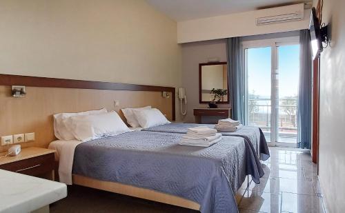 Habitación de hotel con 2 camas y ventana en Arisvi All Seasons Hotel en Skala Kallonis