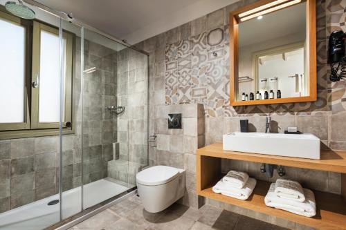 a bathroom with a toilet and a sink and a shower at Callisto Seaside Homes & Suites in Marathopolis